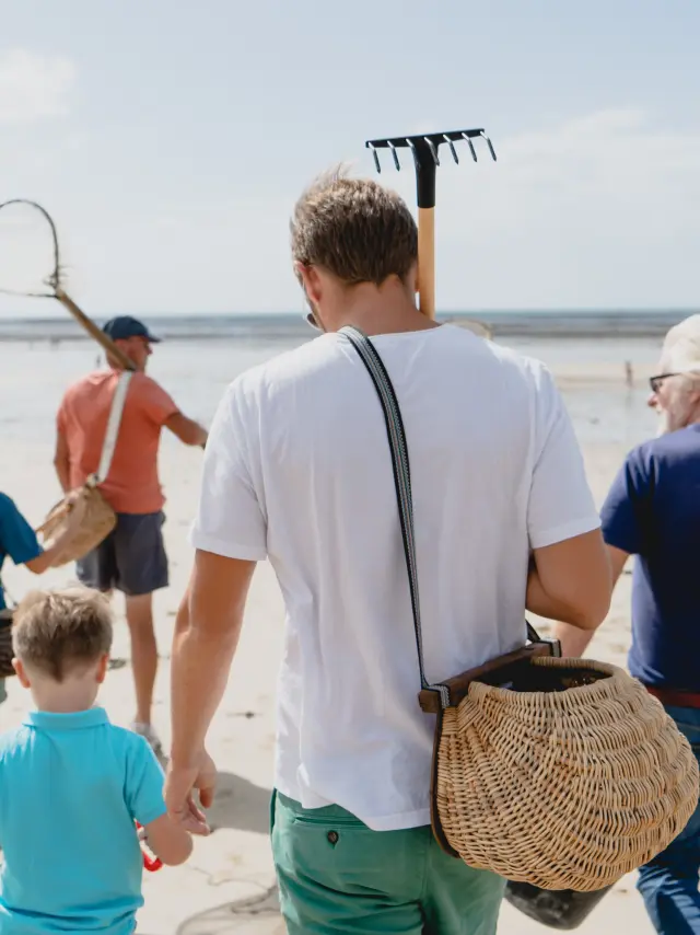 A family walking on the beach with tools to search for shells
