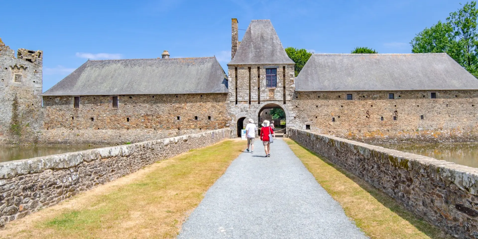 Deux personnes marchent vers l'entrée du Château de Gratot