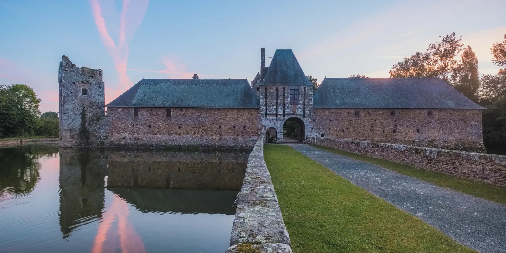 Château de Gratot avec douves au coucher du soleil