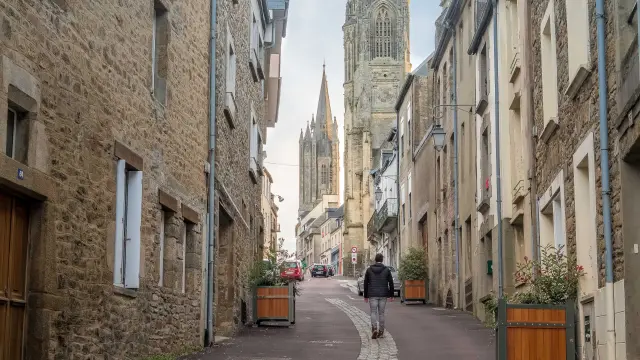 Une rue pavée menant à une cathédrale avec des bâtiments en pierre de chaque côté