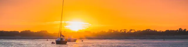 A sailboat on the water at sunset