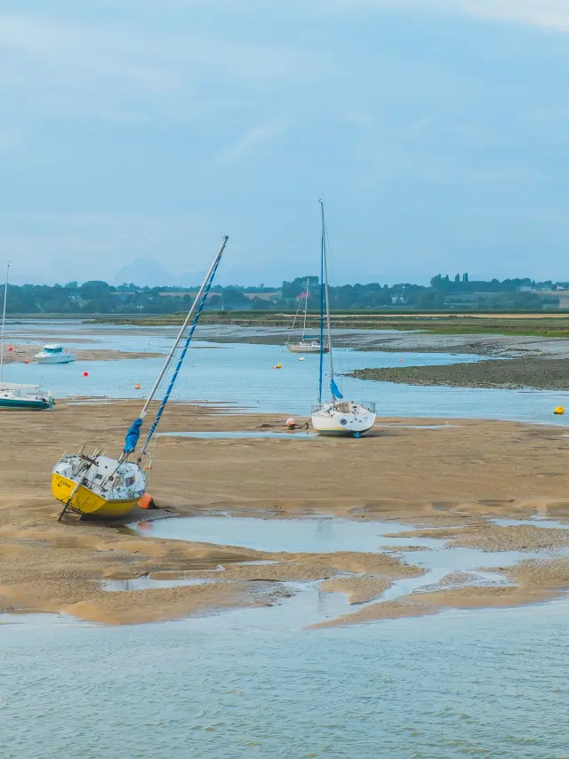 Mehrere Boote auf einem schlammigen Strand mit flachem Wasser gestrandet