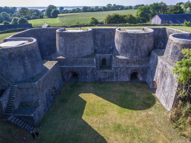 Aerial view of a stone fortress with thick walls and round towers