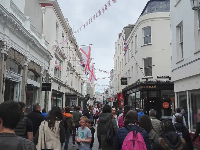 Shopping street with people walking and flags hanging