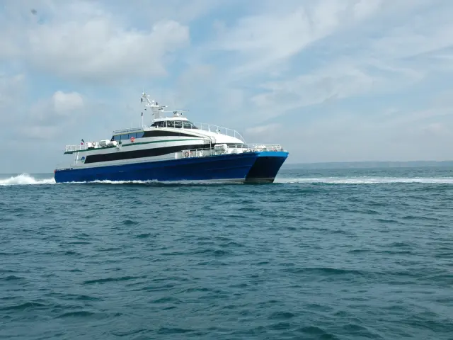 Blue and white ferry sailing on calm waters