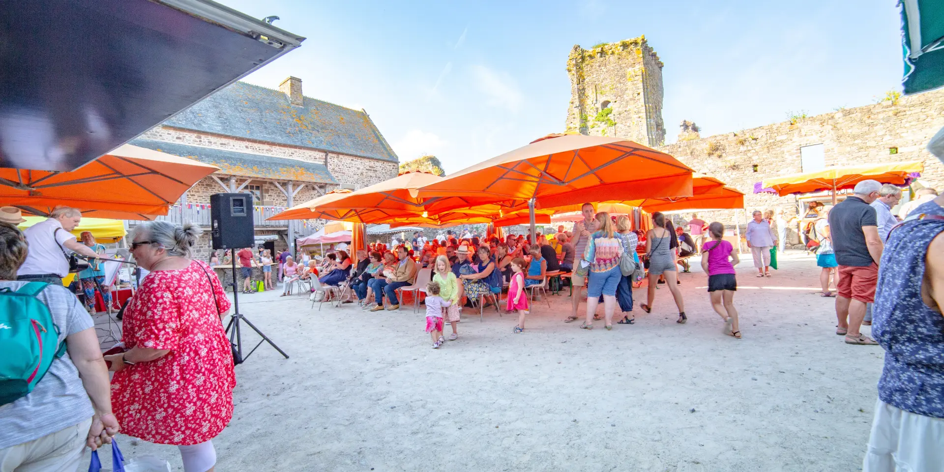Village festival with orange tents and people dancing