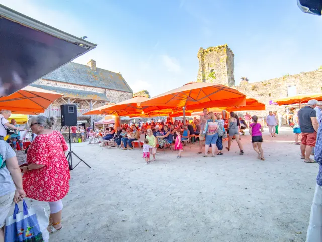 Fête de village avec des tentes orange et des gens en train de danser