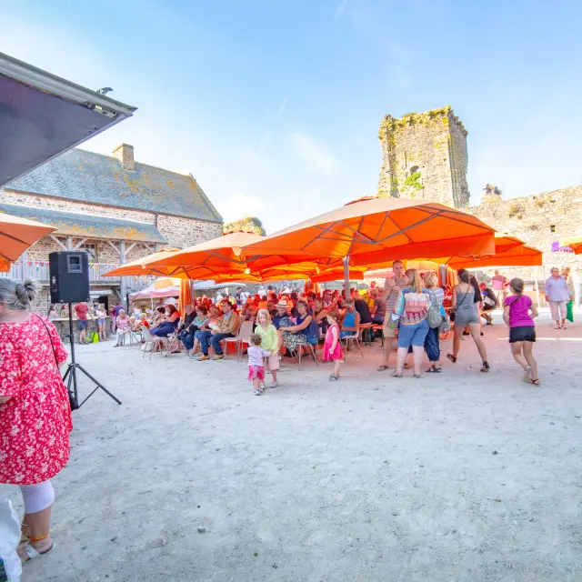 Village festival with orange tents and people dancing