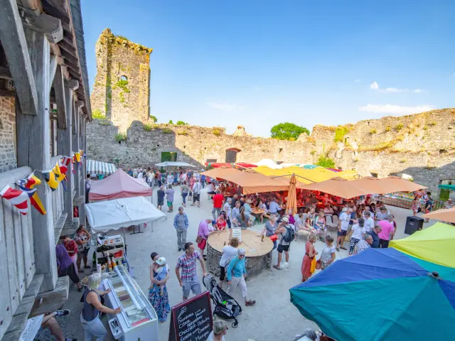 Marché animé dans une forteresse avec des tentes colorées et des visiteurs