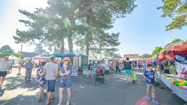 Une foule animée lors d'un marché en plein air sous un ciel dégagé
