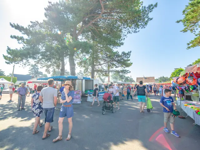 Une foule animée lors d'un marché en plein air sous un ciel dégagé