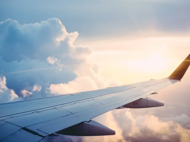 Vue depuis l'intérieur d'un avion, montrant l'aile de l'avion et les nuages