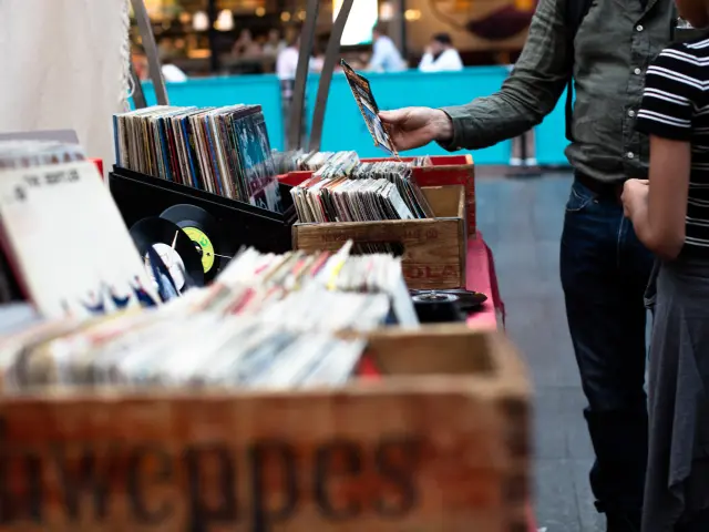 Personen, die Schallplatten auf einem Vintage-Schallplattenmarkt durchblättern