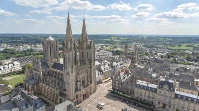 Aerial view of a Gothic cathedral with pointed spires and a surrounding town