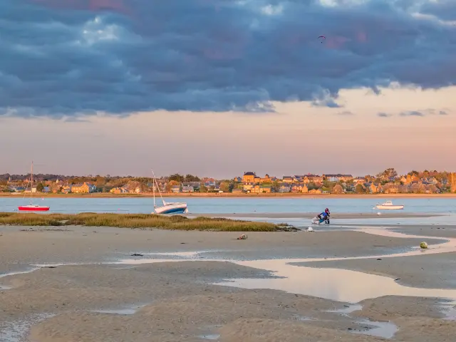 Beach with boats and people at sunset