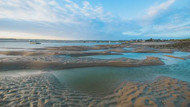 Niedrigwasser an einem Strand mit Wasserpfützen und Fußabdrücken
