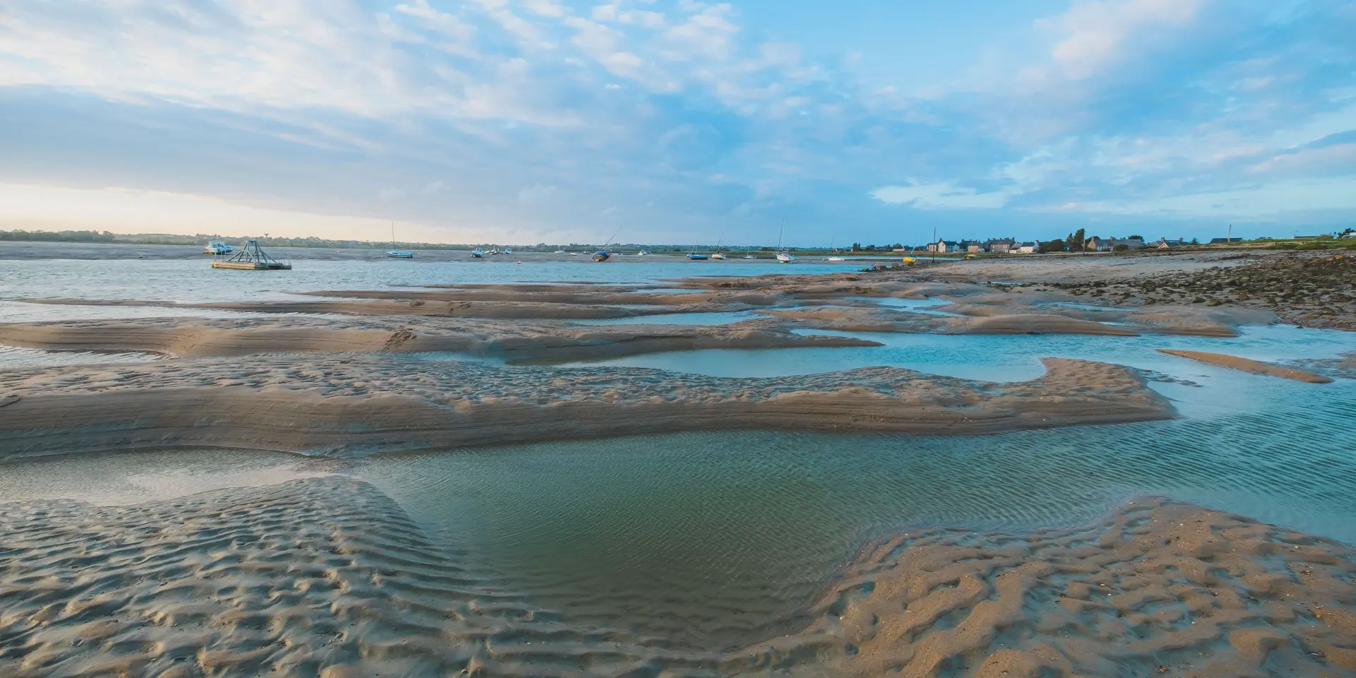 Low tide on a beach with water pools and footprints