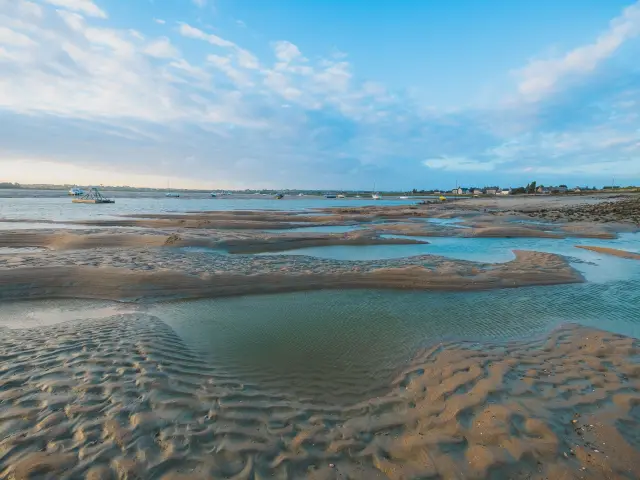 Low tide on a beach with water pools and footprints