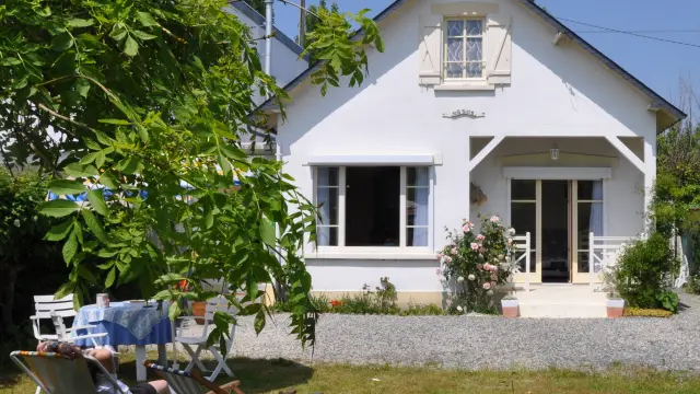 White house with garden and lounge chairs