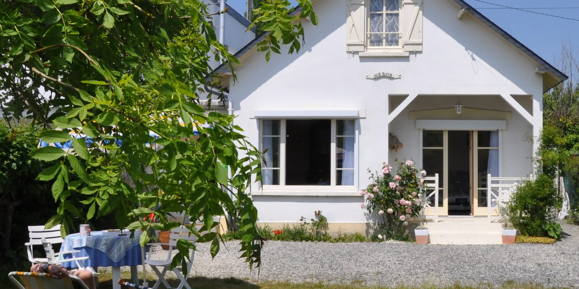 White house with garden and lounge chairs