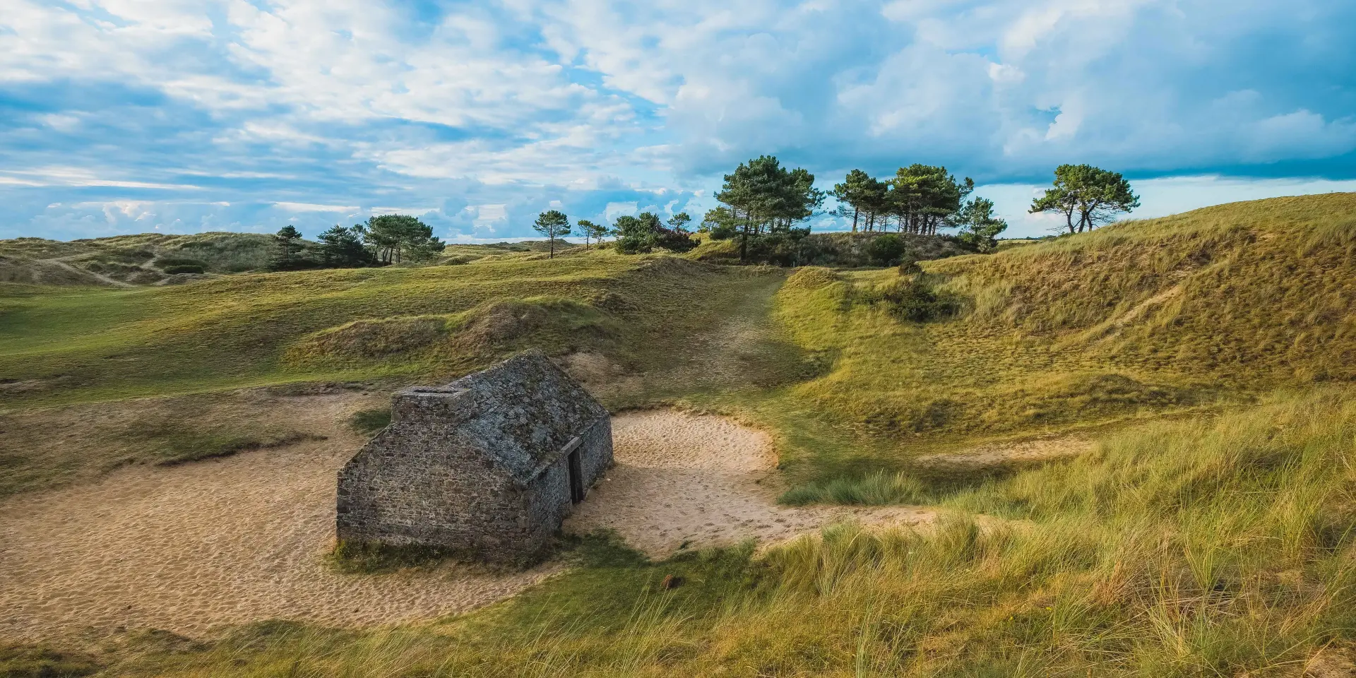 Steinbunker umgeben von Dünen und Vegetation