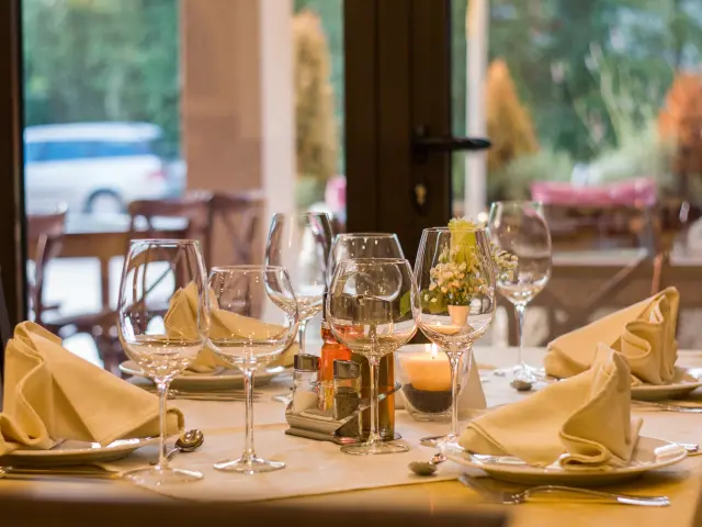 Table dressée avec des verres à vin, des serviettes en tissu et des couverts
