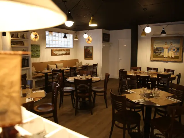 Interior of a restaurant with round tables and wooden chairs