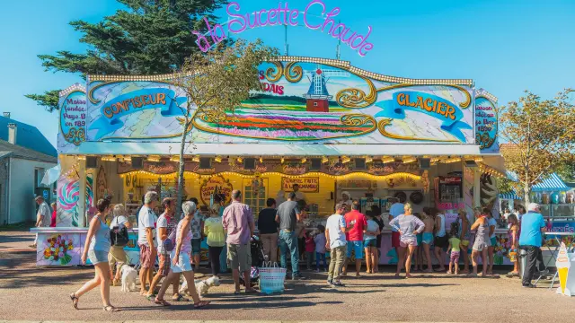 Ein Zuckerwatte-Stand mit Menschen, die in der Schlange stehen, um Leckereien zu kaufen