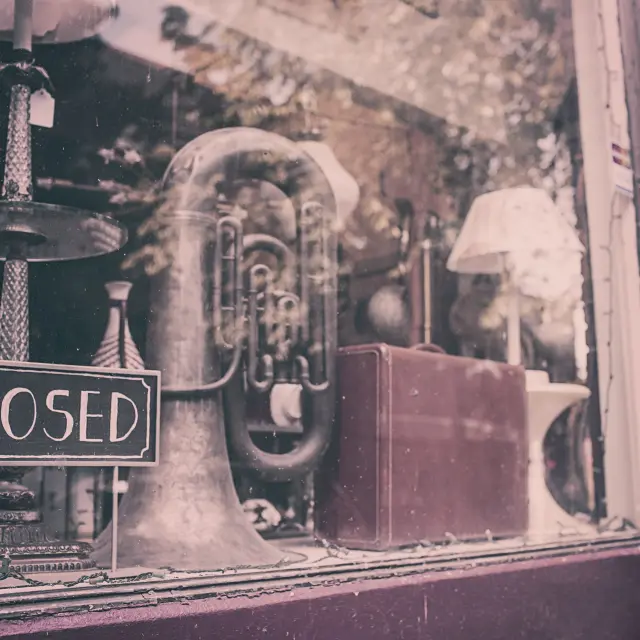 Vitrine de magasin avec un panneau 'Fermé' et des instruments de musique