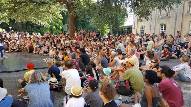 Menschen sitzen und hören einem Open-Air-Konzert zu