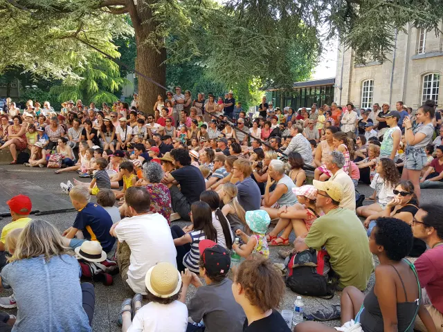 Menschen sitzen und hören einem Open-Air-Konzert zu