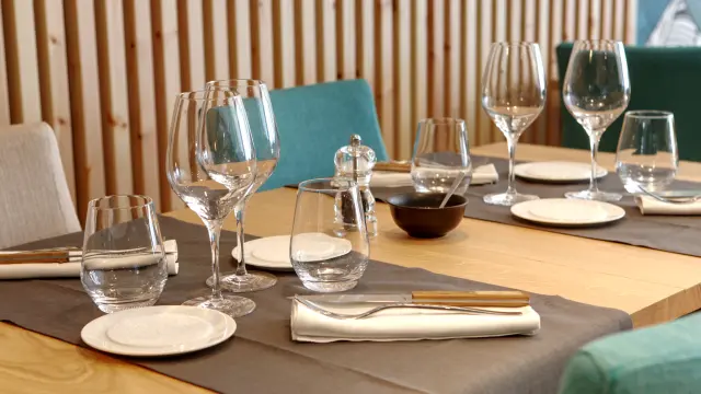 Tisch mit Weingläsern, Besteck und Servietten gedeckt