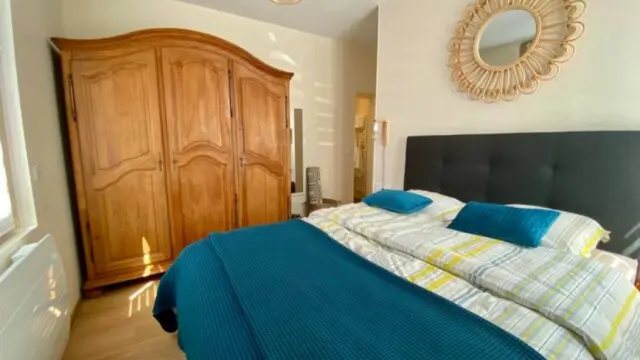 Schlafzimmer mit Doppelbett, Holzschrank und dekorativem Spiegel