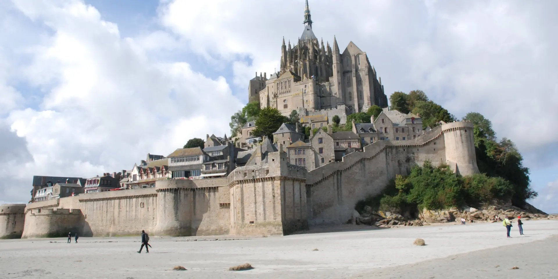 Mont Saint-Michel with visitors on the beach