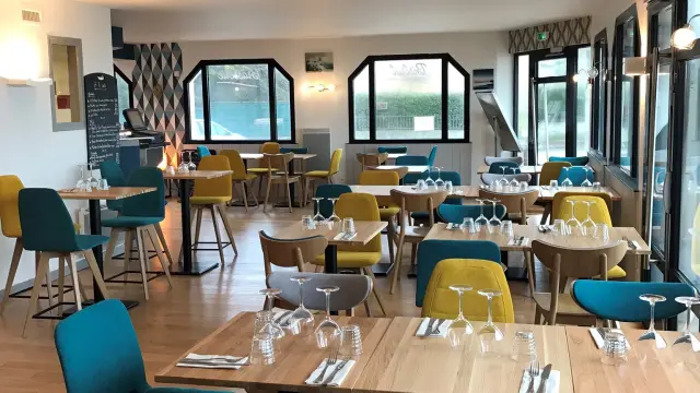 Innenraum eines Restaurants mit farbigen Tischen und Stühlen