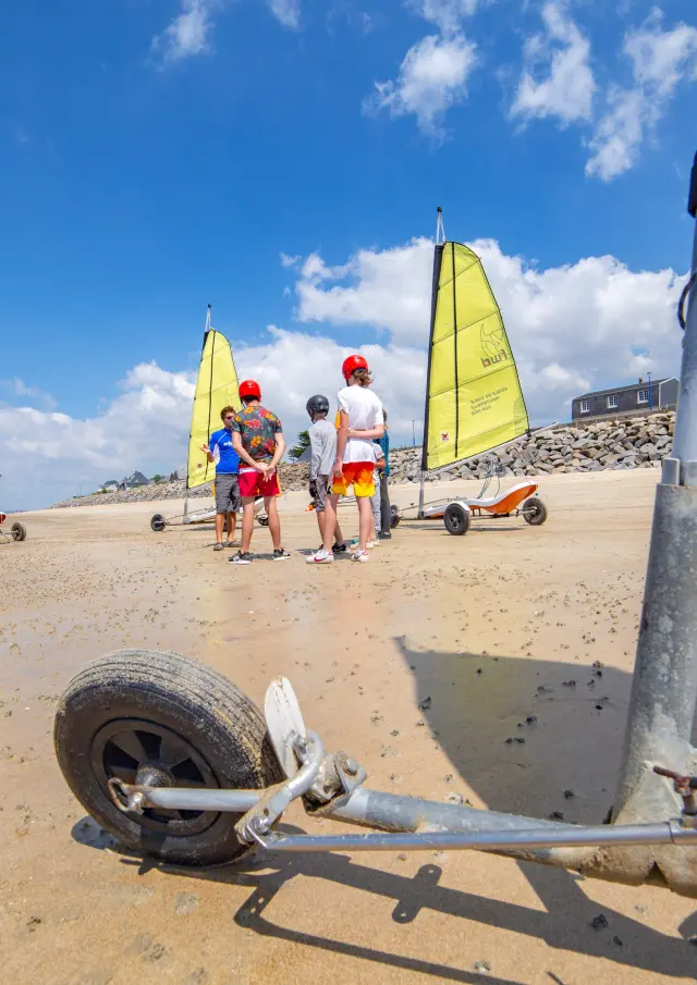 Gruppe von Menschen, die lernen, Landsegler an einem Strand zu verwenden