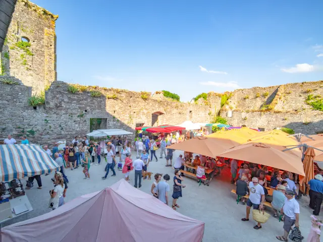 Belebter Markt in einer Festung mit bunten Ständen und Besuchern
