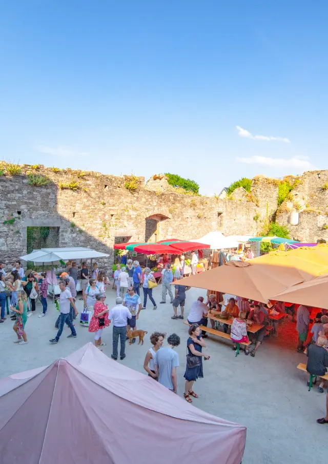 Belebter Markt in einer Festung mit bunten Ständen und Besuchern