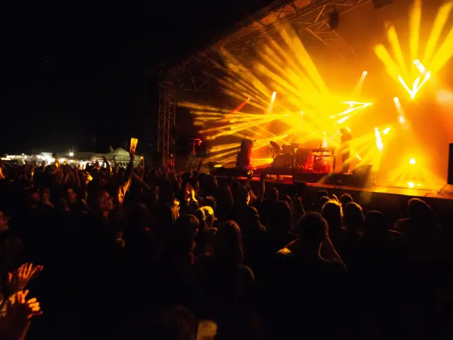 Foule assistant à un concert avec des projecteurs lumineux