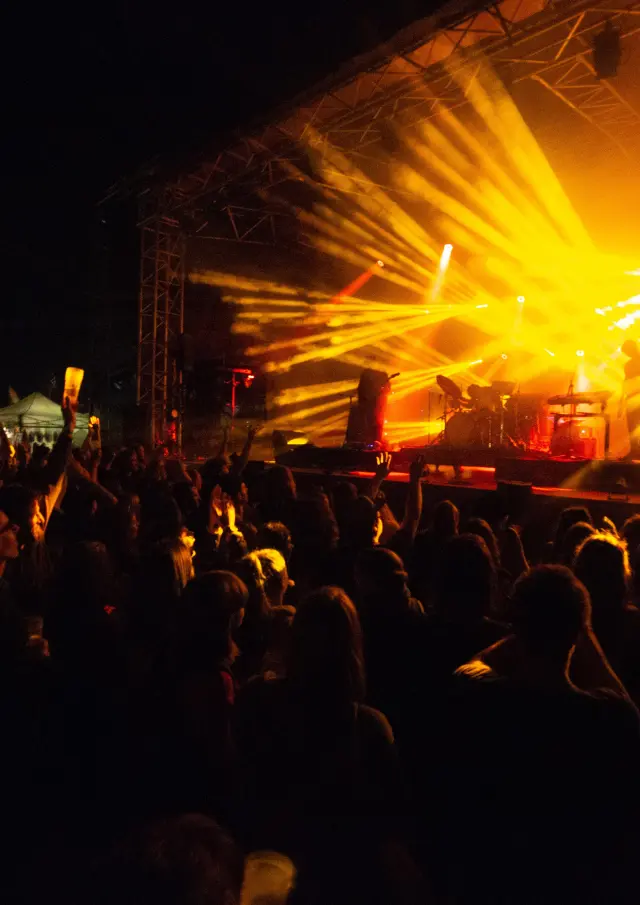 Menschenmenge bei einem Konzert mit hellen Scheinwerfern