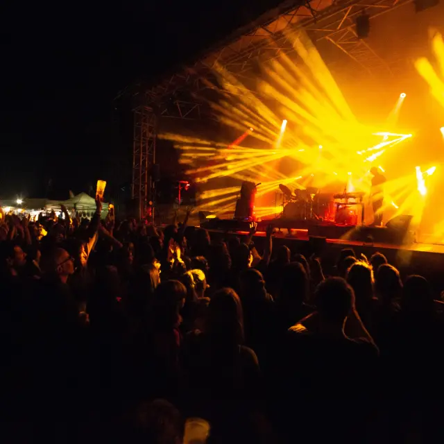 Foule assistant à un concert avec des projecteurs lumineux