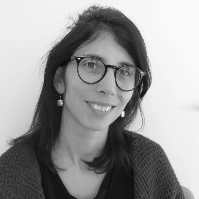 Portrait d'une femme souriante portant des lunettes et un pull