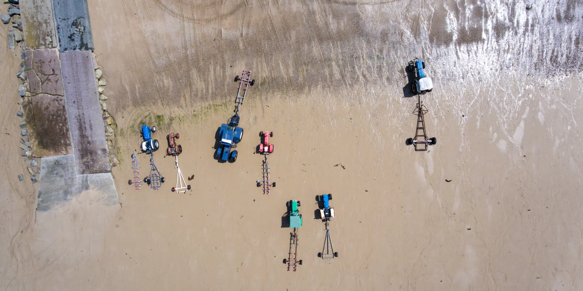 Tracteurs et remorques sur le sable vus du ciel