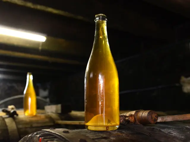 Two bottles of artisanal beer on a wooden barrel