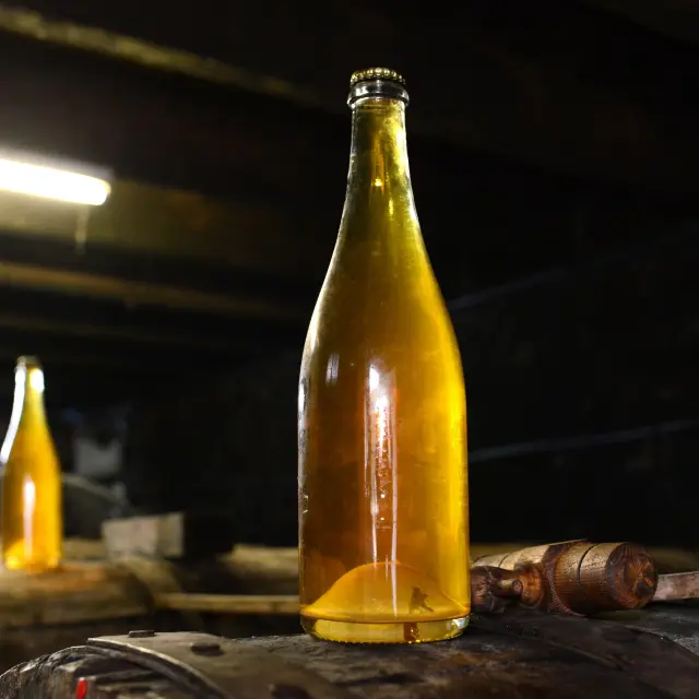 Two bottles of artisanal beer on a wooden barrel