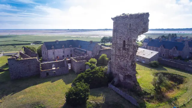 Luftaufnahme der Ruinen einer mittelalterlichen Burg mit einem teilweise eingestürzten Turm