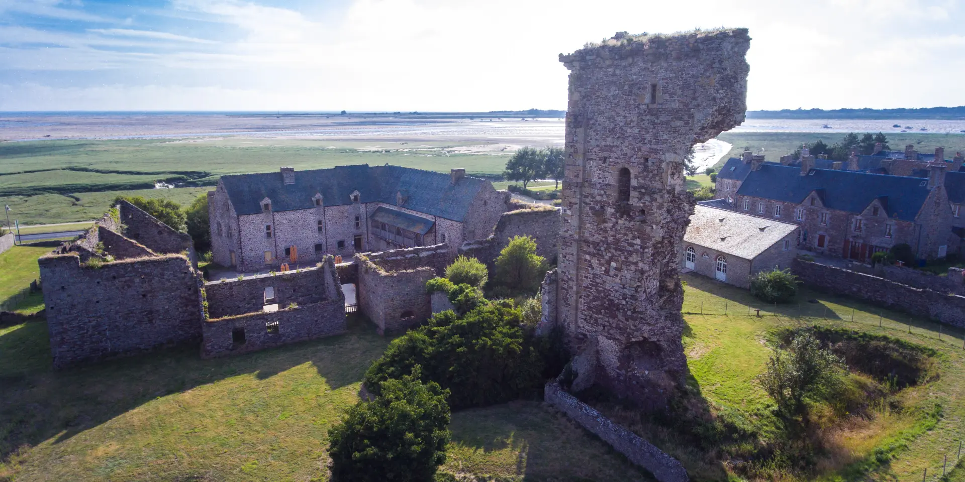 Luftaufnahme der Ruinen einer mittelalterlichen Burg mit einem teilweise eingestürzten Turm
