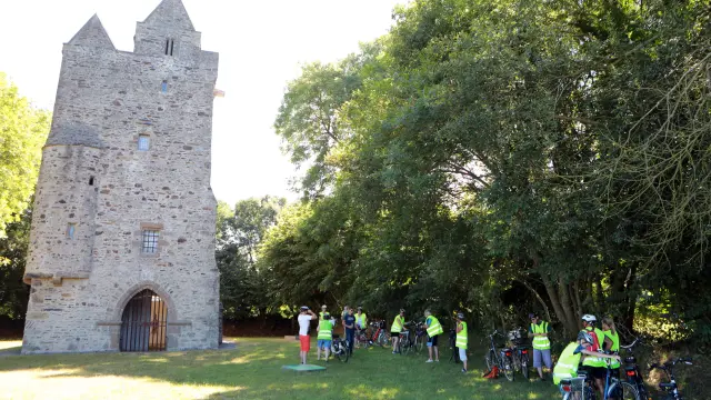 Group of cyclists in front of a medieval tower