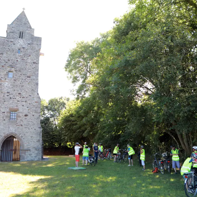 Group of cyclists in front of a medieval tower