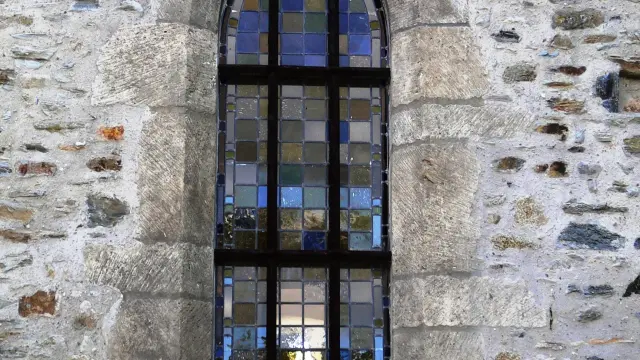 Gothic window with colorful stained glass in a stone wall